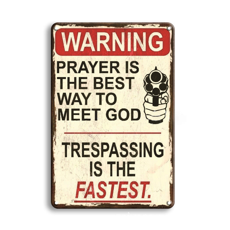 Vintage-style metal sign with humorous text about prayer and gun violence.
