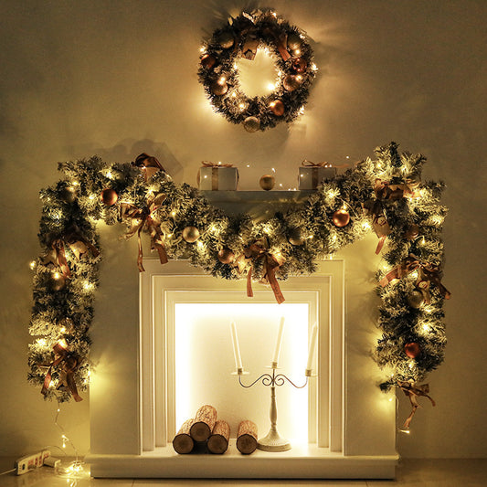 Decorative fireplace with garlands, wreath, and candles on a neutral background