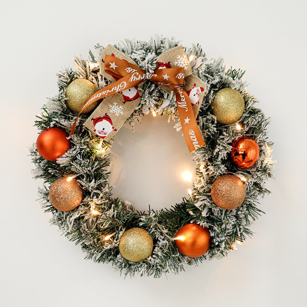 Decorative Christmas wreath with ornaments and a ribbon on a light background