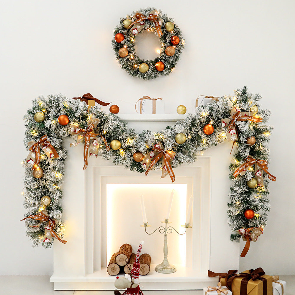 Decorated fireplace with Christmas garland, wreath, and presents on a white wall.
