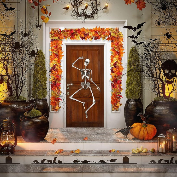 Halloween-themed door decoration with skeleton, pumpkins, and autumn leaves.