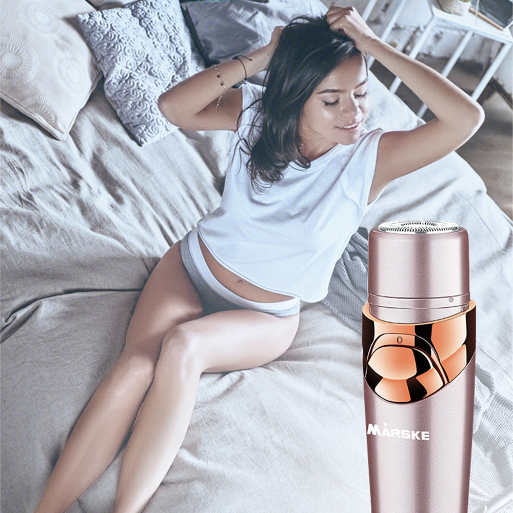 Woman sitting on a bed with a hair removal device in the foreground